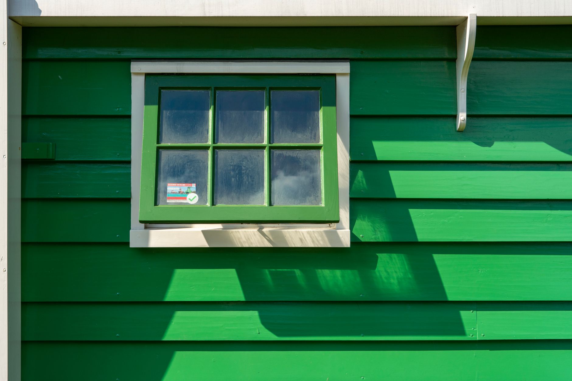 Fenêtre sur la façade en bois peint en vert d'une maison