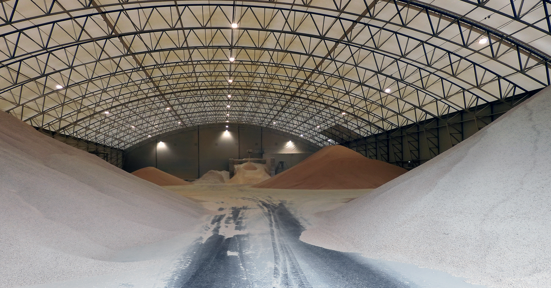 Tas de granulés de bois en vrac stockés sous la charpente métallique d'un grand entrepôt